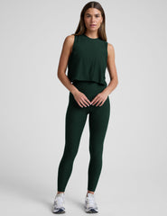 model wearing a green sleeveless cropped top and green leggings on a light gray background.