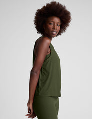 model wearing a green scoop neck tank top and leggings against a plain background.