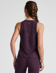 model wearing a purple relaxed fit tank top and leggings on a light gray background.