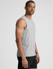 man wearing a gray sleeveless shirt against a plain background.