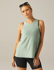 green high-neck tank top with a twist cutout detail on the back straps.