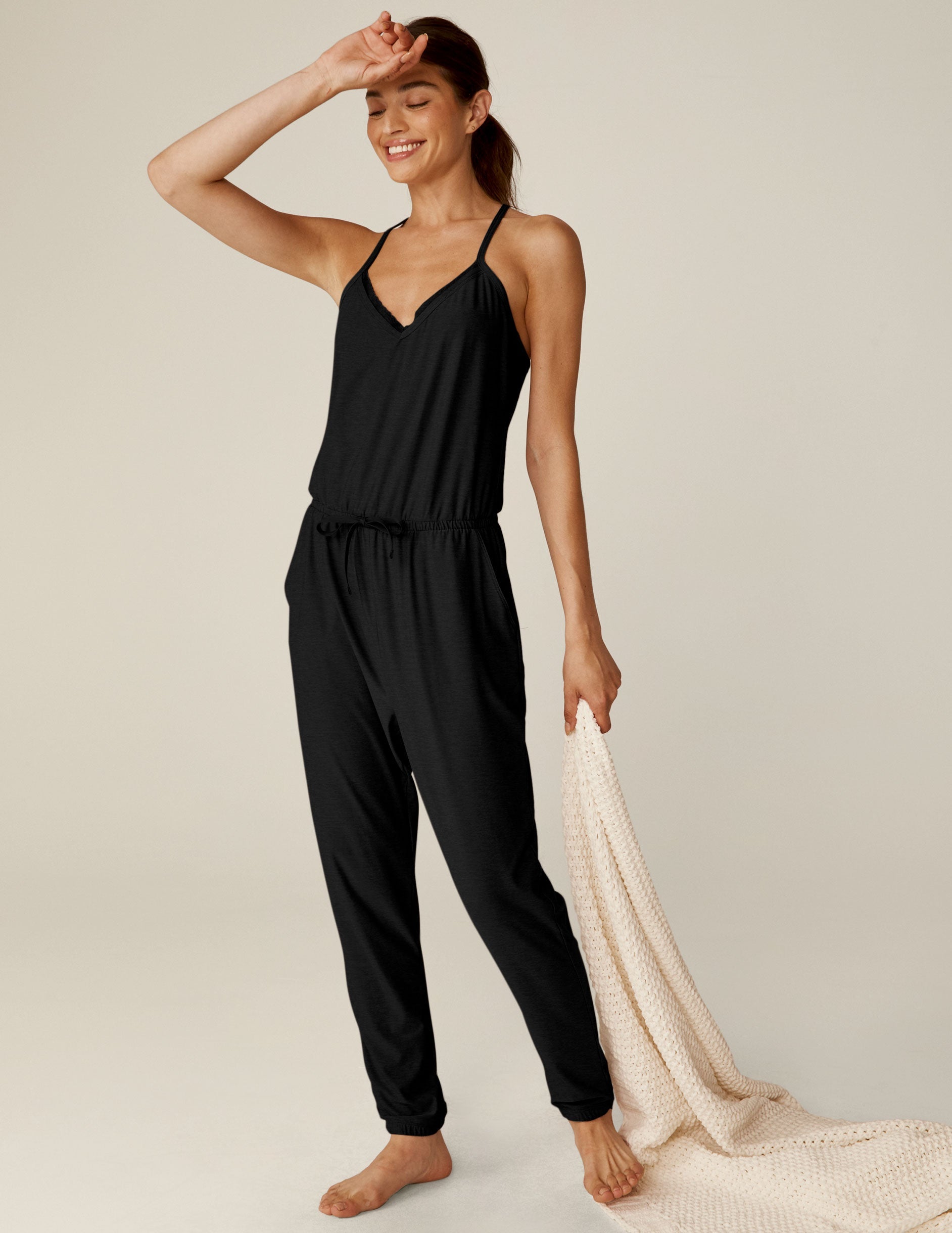 black midi jumpsuit with drawstring at waist and a lace trim at neckline.