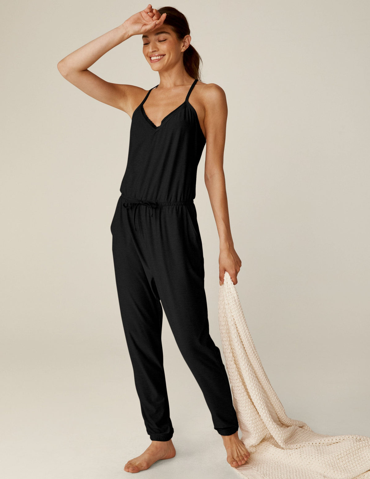 black midi jumpsuit with drawstring at waist and a lace trim at neckline.