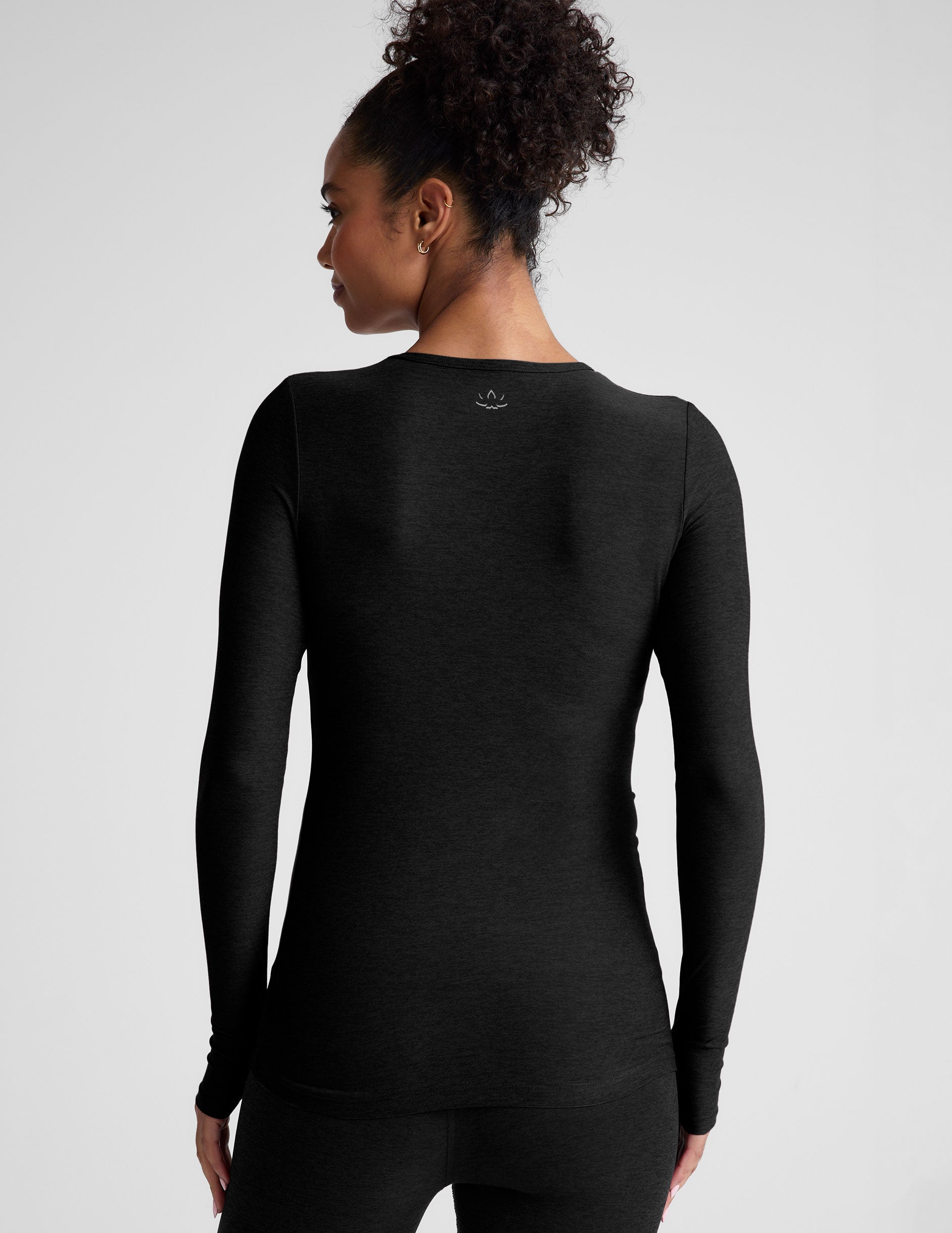 black crew neck long sleeve top with thumb holes.