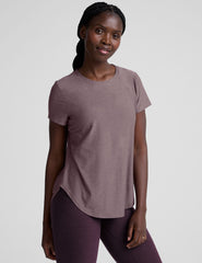 model wearing a mauve t-shirt and leggings on a plain background.