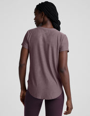 model wearing a mauve t-shirt and leggings on a plain background.