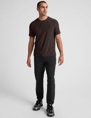 model wearing a brown men's short sleeve t-shirt against a gray background.