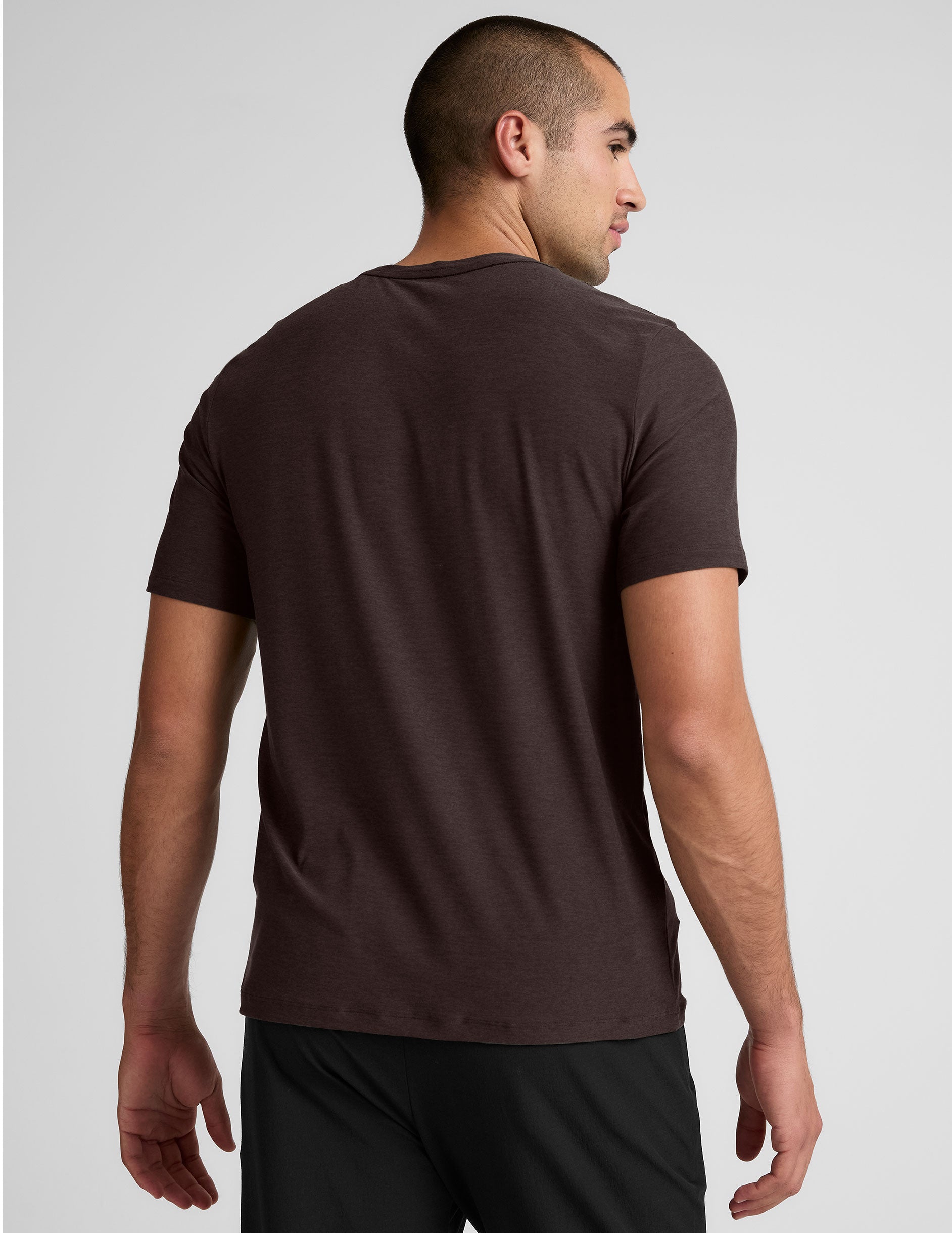 model wearing a brown men's short sleeve t-shirt against a gray background.