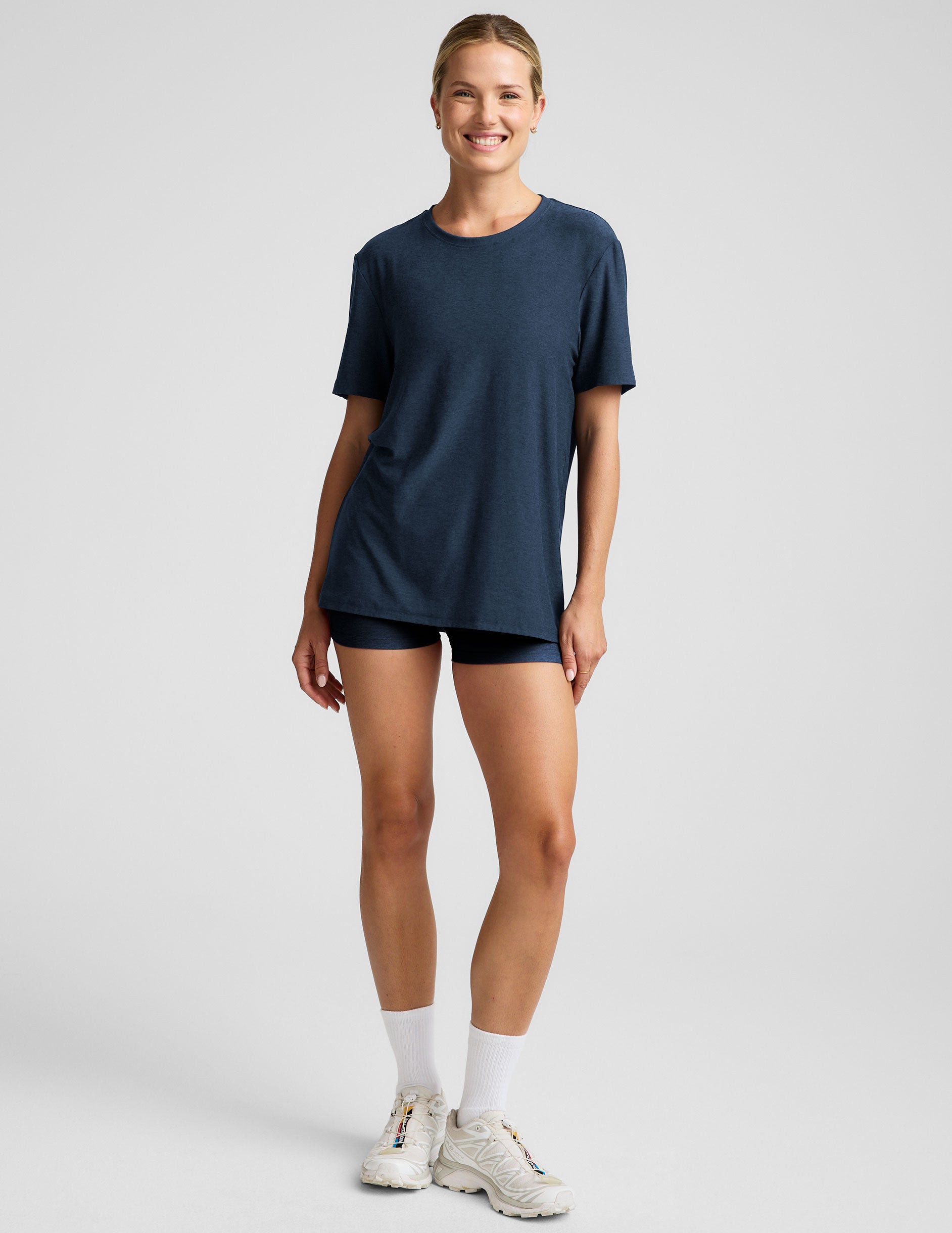 model wearing a blue oversized men's t-shirt and biker shorts against a plain background.