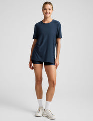 model wearing a blue oversized men's t-shirt and biker shorts against a plain background.