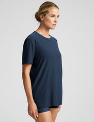 model wearing a blue oversized men's t-shirt and biker shorts against a plain background.