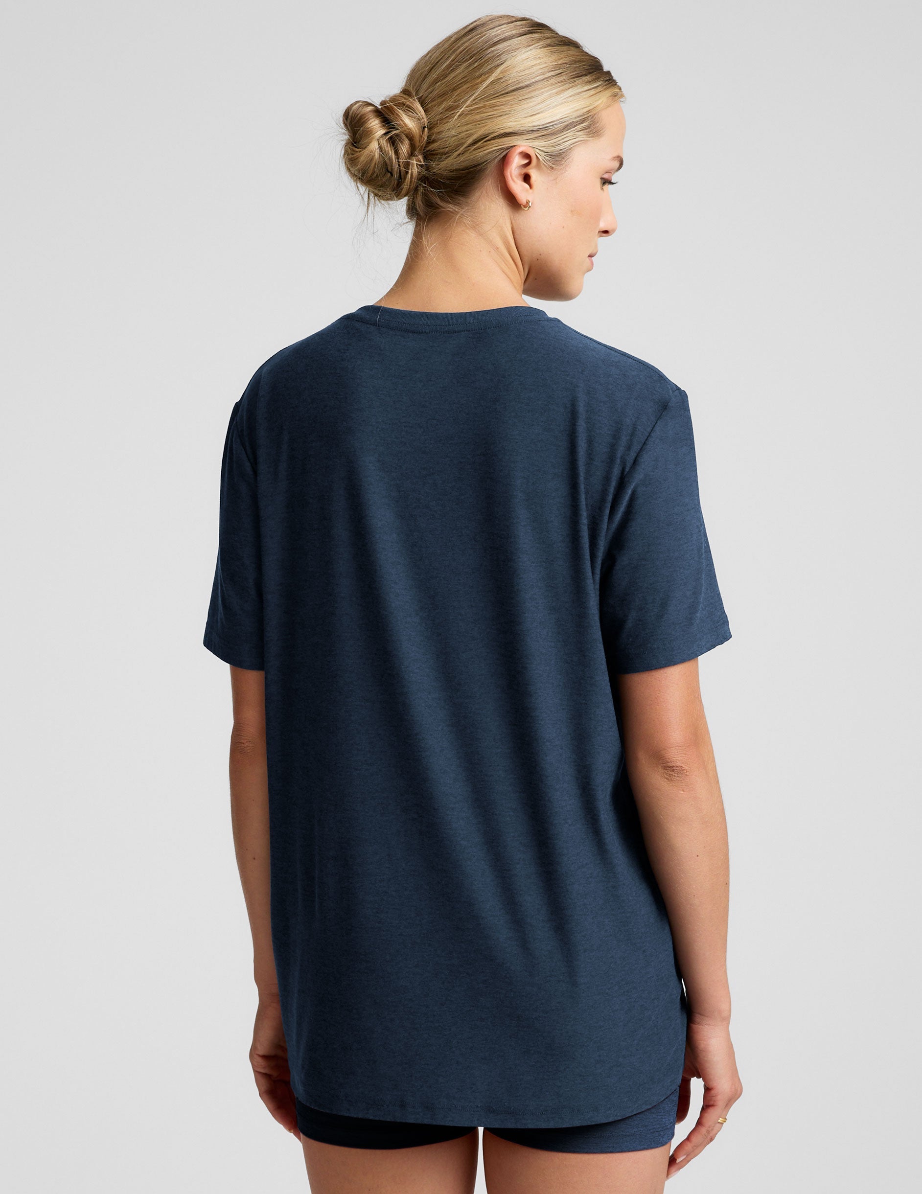 model wearing a blue oversized men's t-shirt and biker shorts against a plain background.