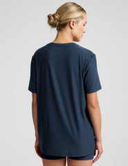 model wearing a blue oversized men's t-shirt and biker shorts against a plain background.