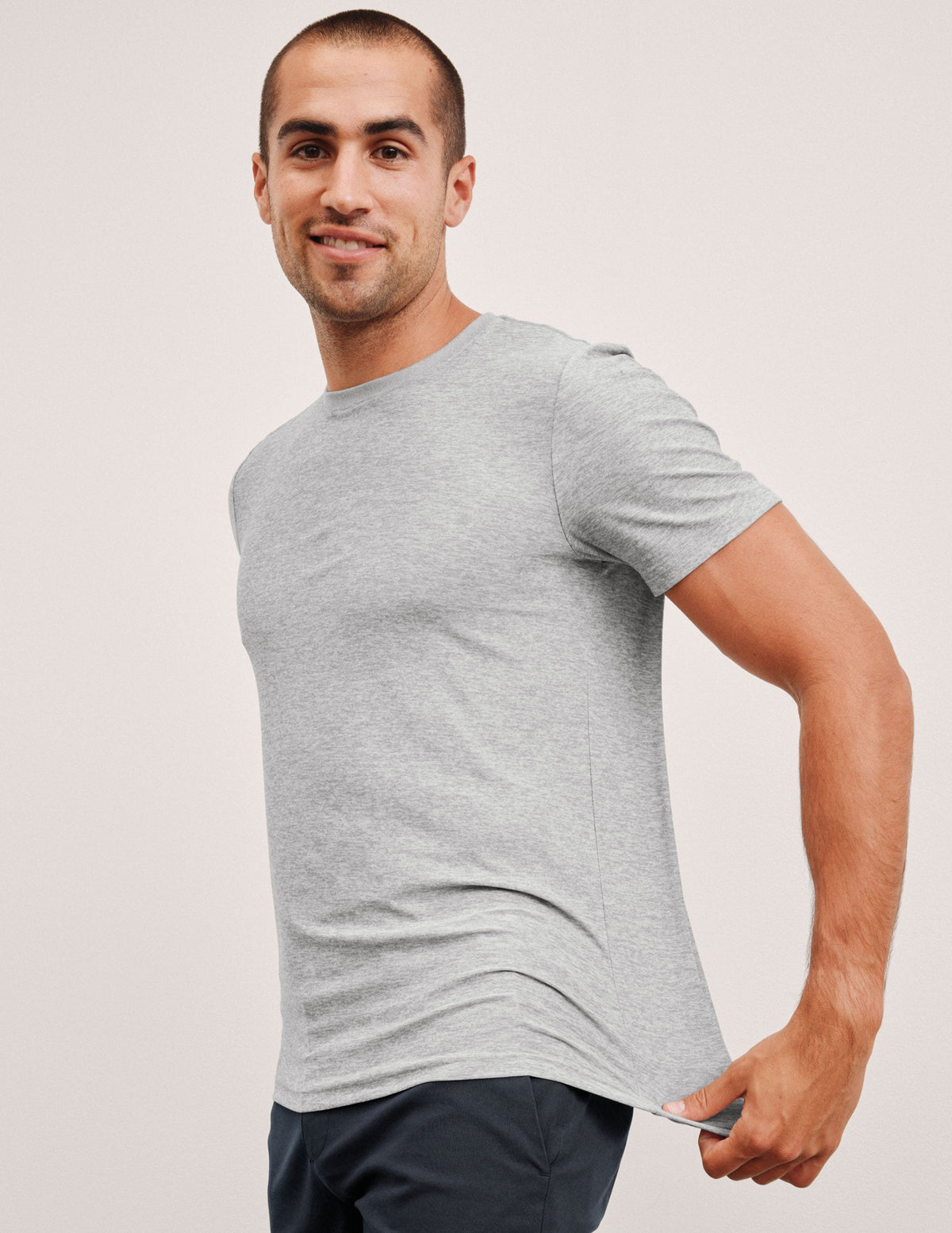 man wearing a gray t-shirt against a plain background.