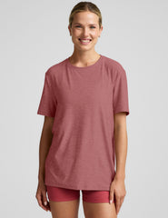 model wearing an oversized men's red t-shirt and shorts on a plain background.