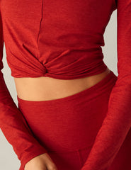 red long sleeve top with a twist detail in front.