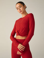 red long sleeve top with a twist detail in front.