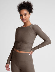brown long sleeve cropped top with shirred detailing on the sides.