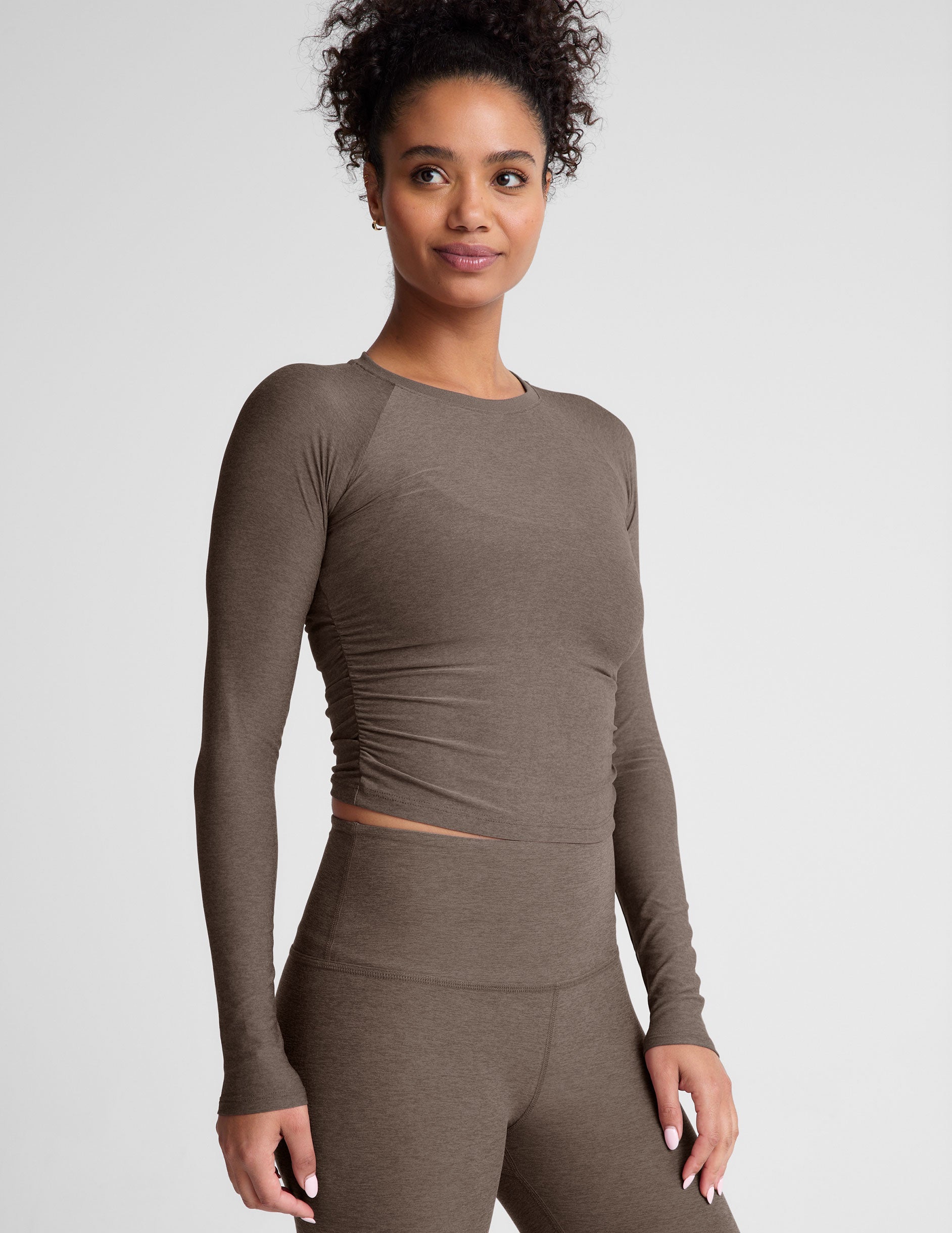 brown long sleeve cropped top with shirred detailing on the sides.