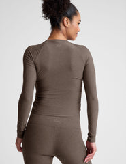 brown long sleeve cropped top with shirred detailing on the sides.