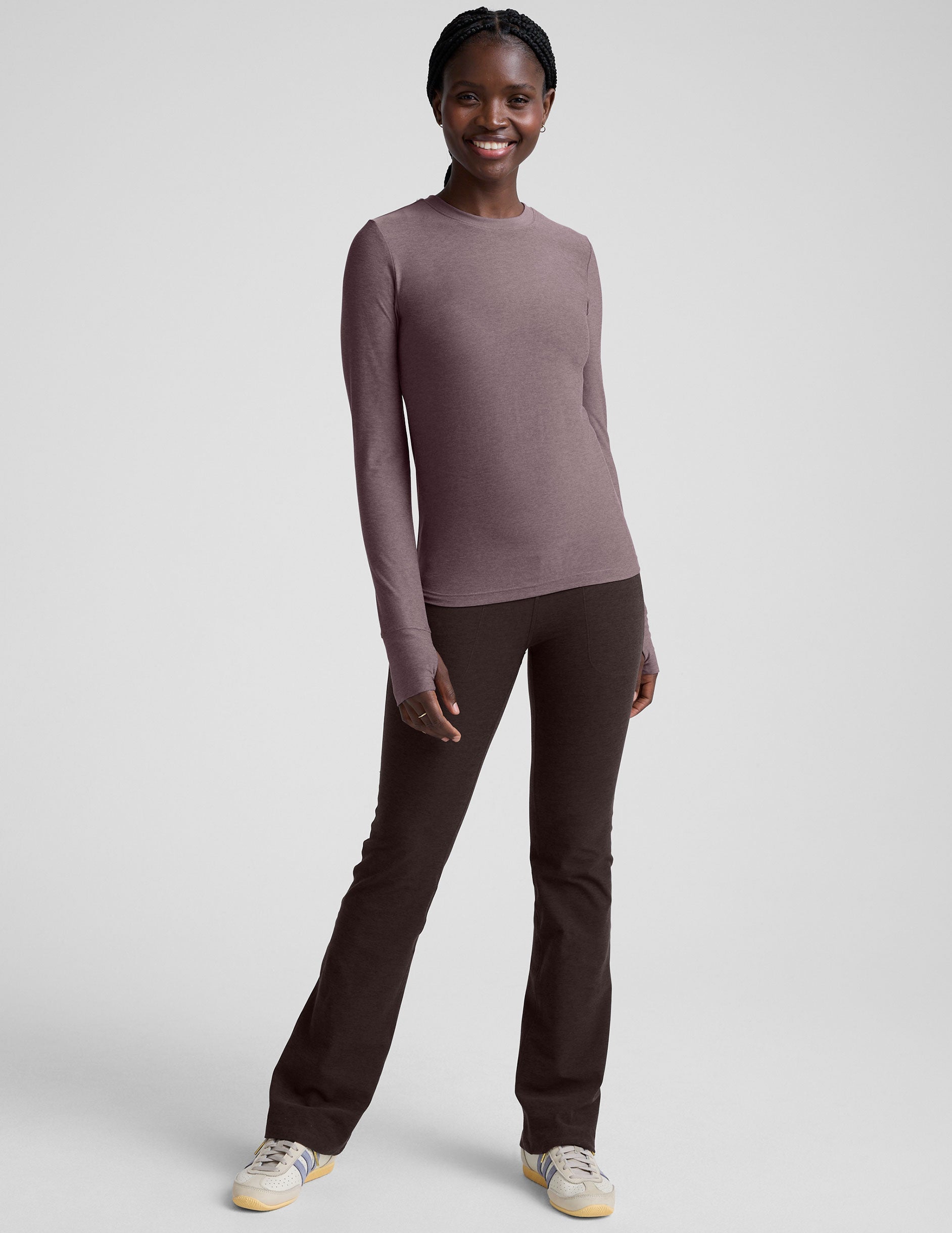 model wearing a mauve long-sleeve fitted crew neck top against a plain background.