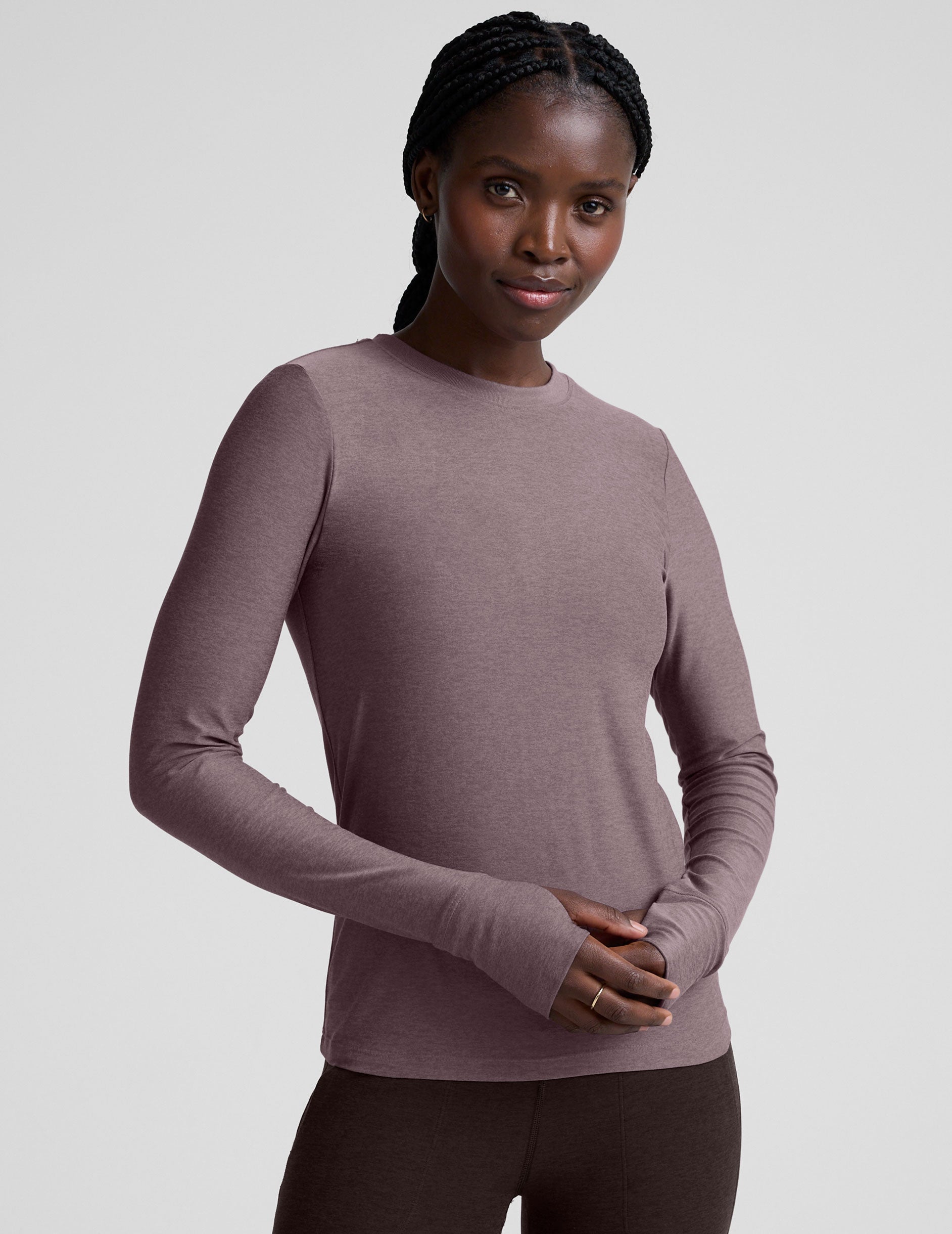 model wearing a mauve long-sleeve fitted crew neck top against a plain background.