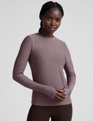 model wearing a mauve long-sleeve fitted crew neck top against a plain background.