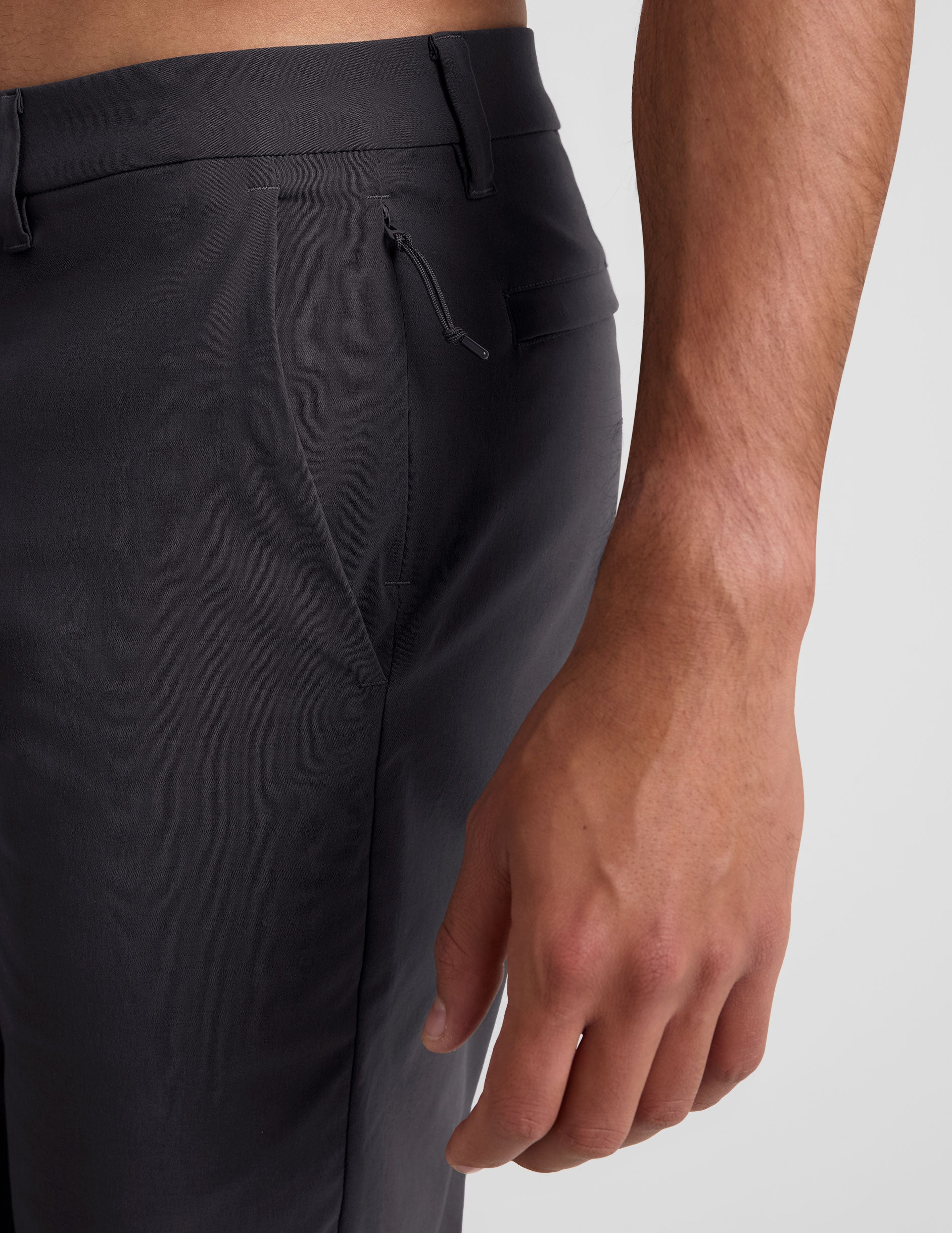 male model wearing a grey t-shirt and chino pants on a light background.