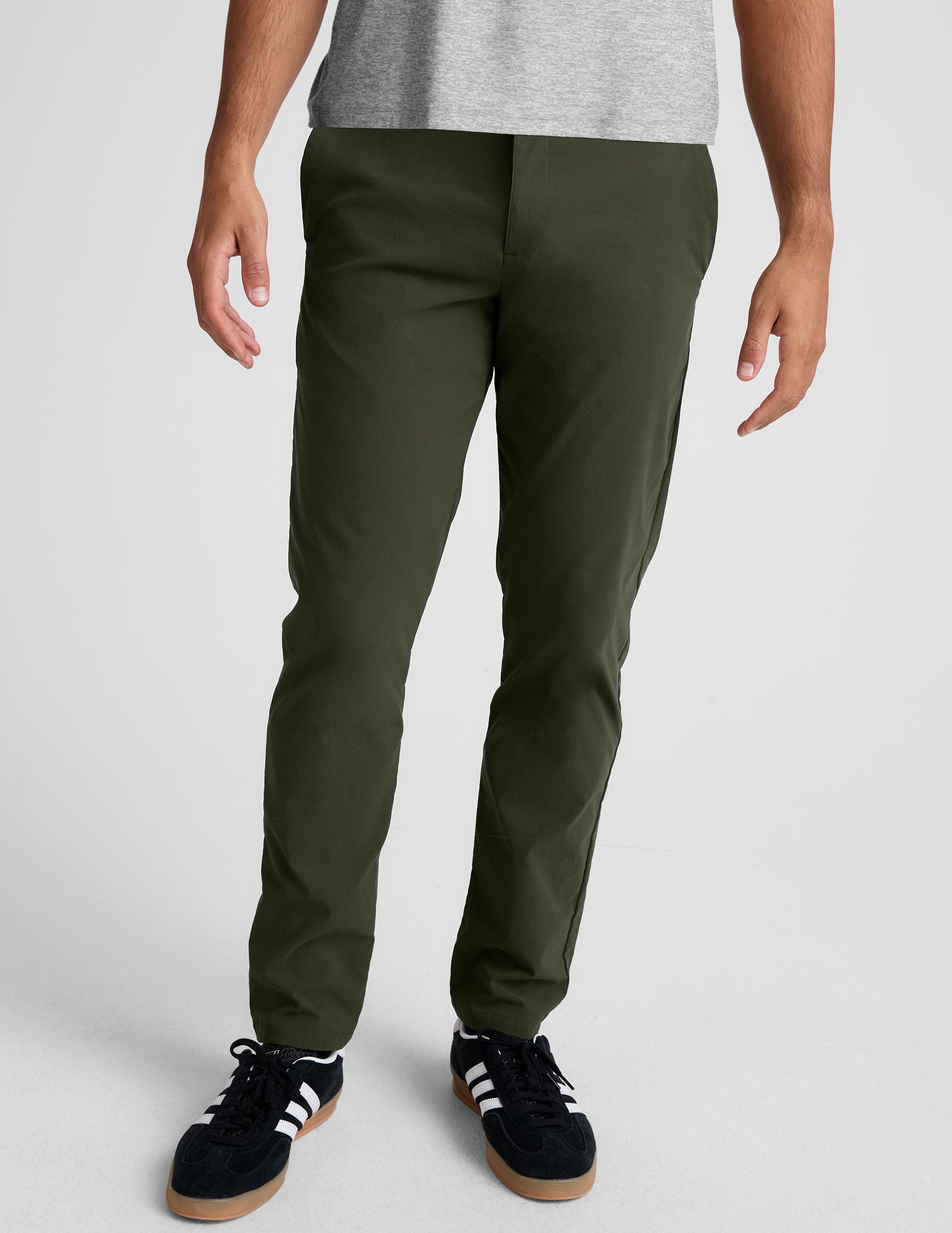 model wearing green men's chino pants on a plain background.
