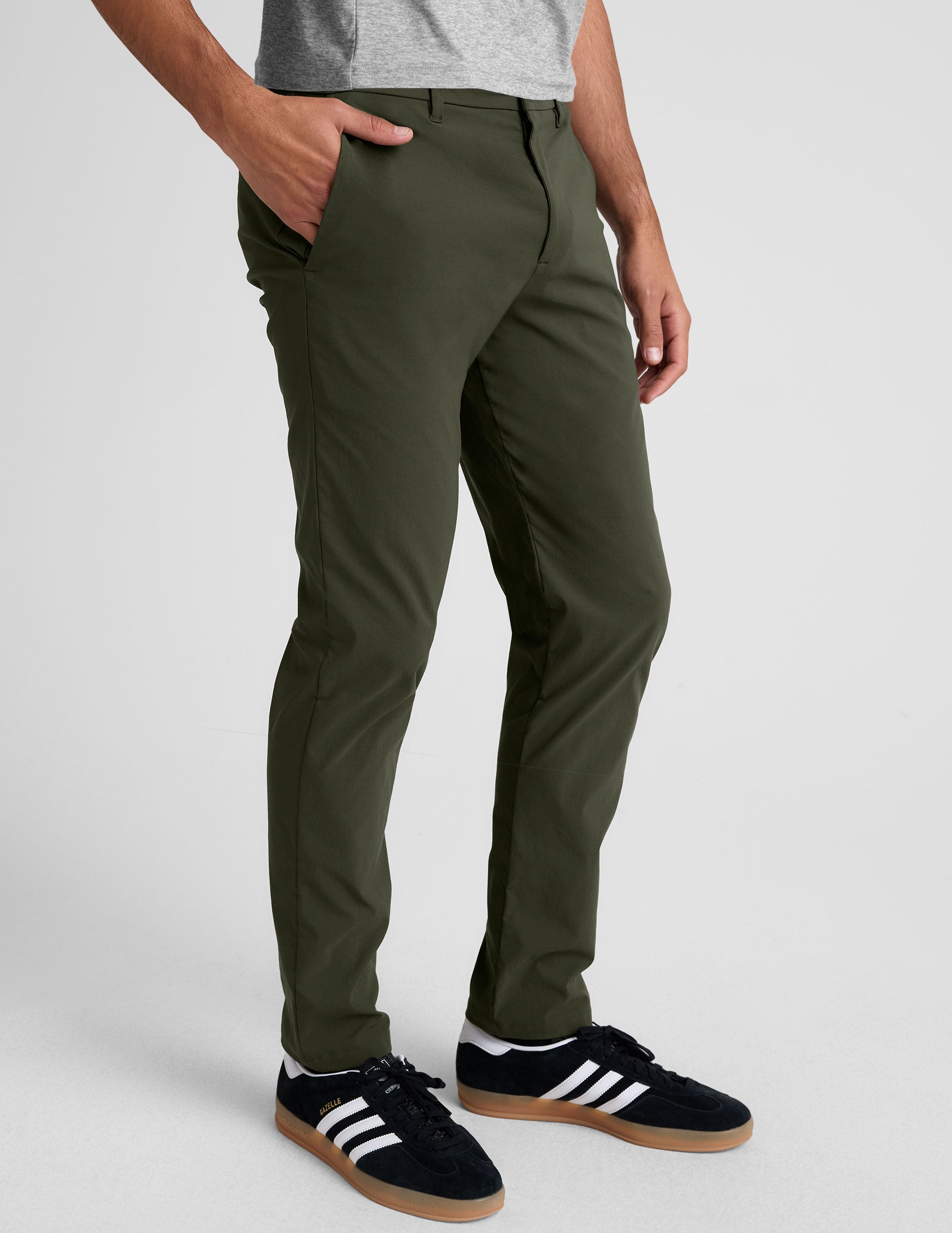 model wearing green men's chino pants on a plain background.