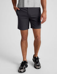 man wearing a grey crew neck t-shirt and black chino shorts with pockets on a plain background.
