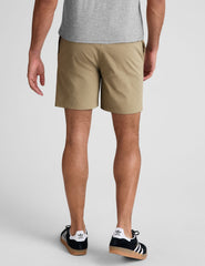 man wearing a grey crew neck t-shirt and beige chino shorts with pockets standing against a plain background.