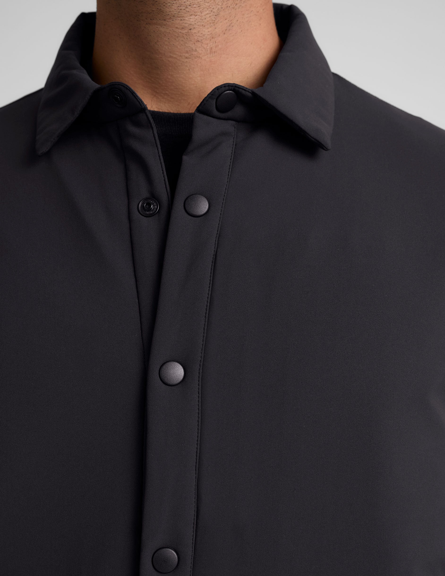black men's button up insulated jacket with a shirt collar and side seam invisible zipper pockets.