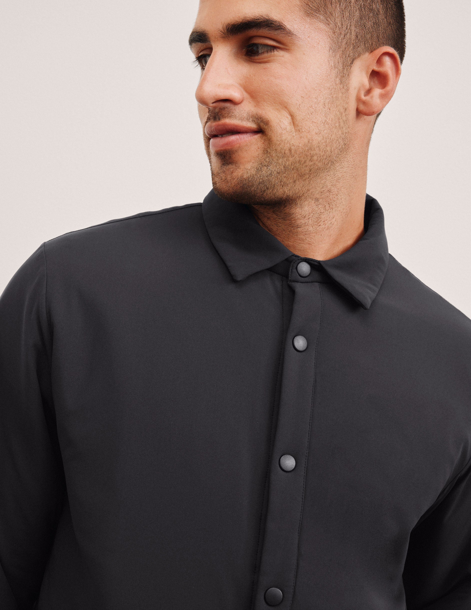 black men's button up insulated jacket with a shirt collar and side seam invisible zipper pockets.