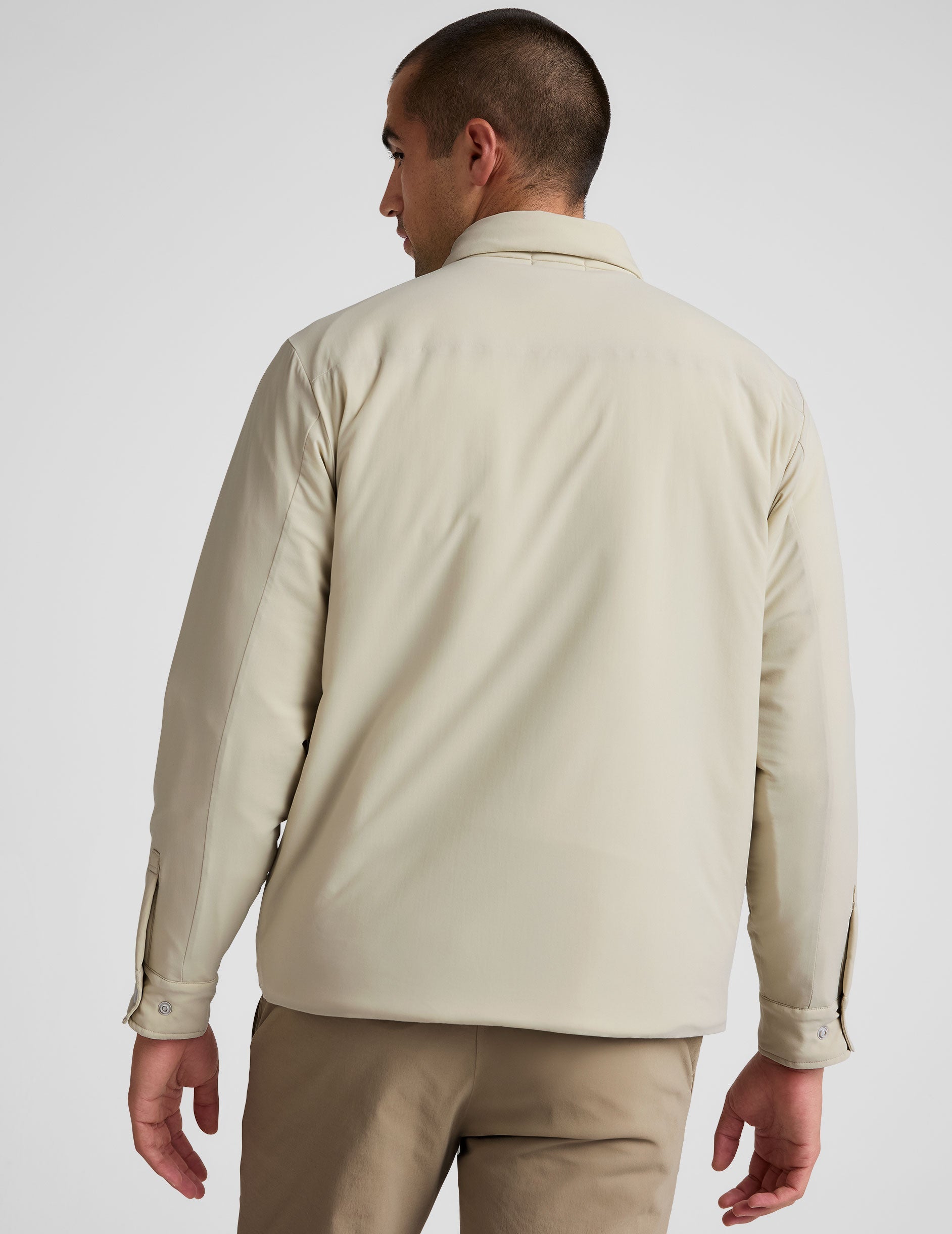 brown men's button up insulated jacket with a shirt collar and side seam invisible zipper pockets.