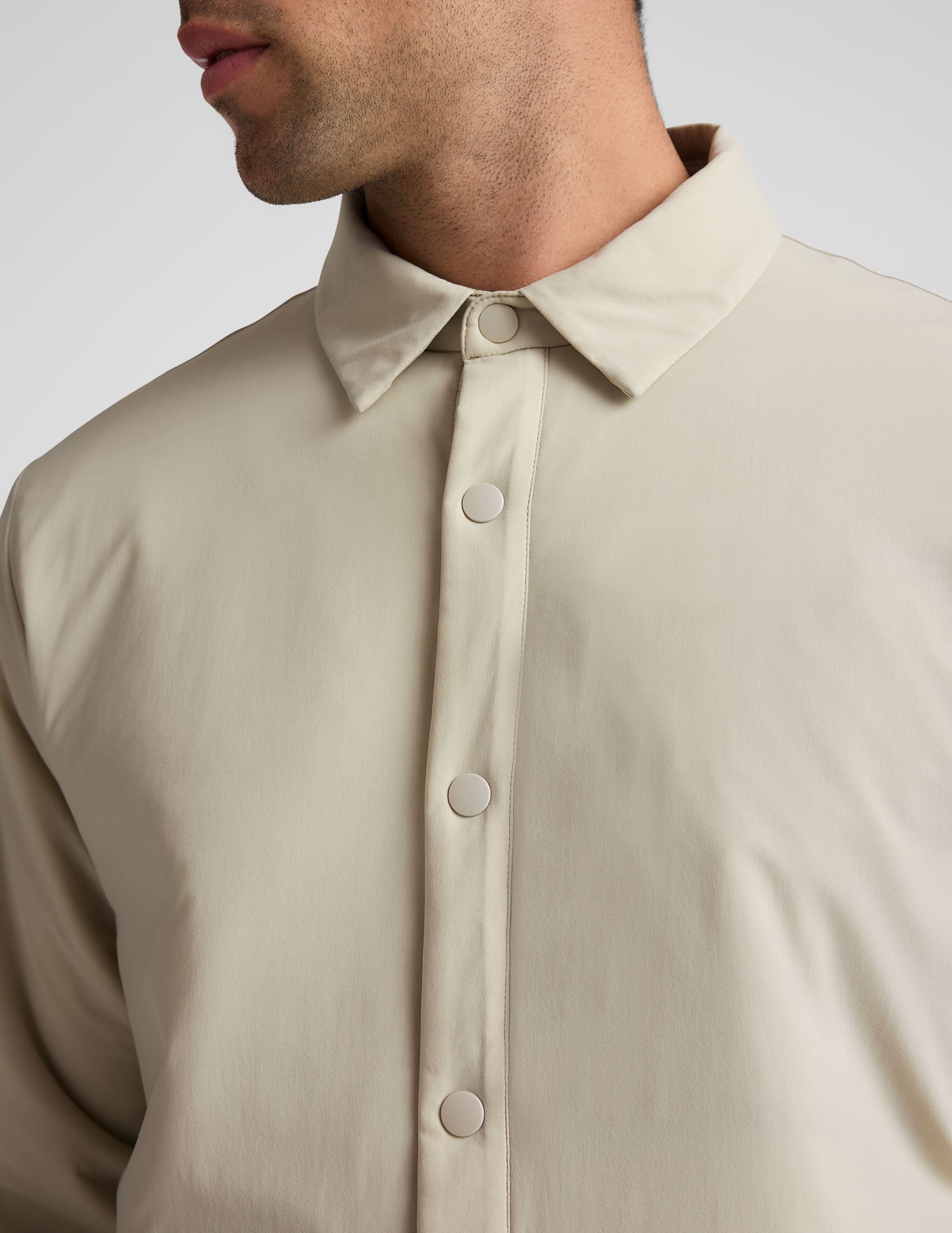 brown men's button up insulated jacket with a shirt collar and side seam invisible zipper pockets.