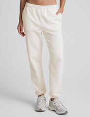woman wearing white fleece sweatpants against a plain background.