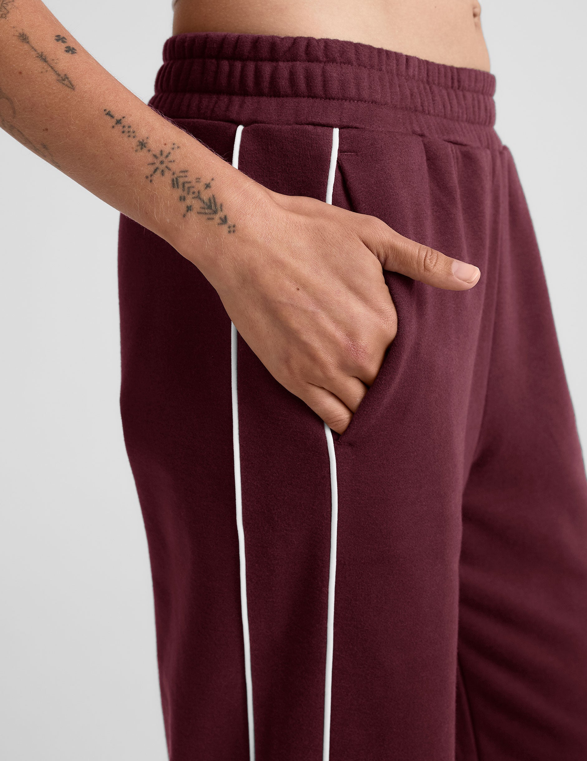 red sweatpant with a mid rise elasticated waistband and contrast piping trim down sides of leg.
