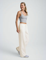 model wearing a grey tank and white fleece wide leg pants against a plain background.