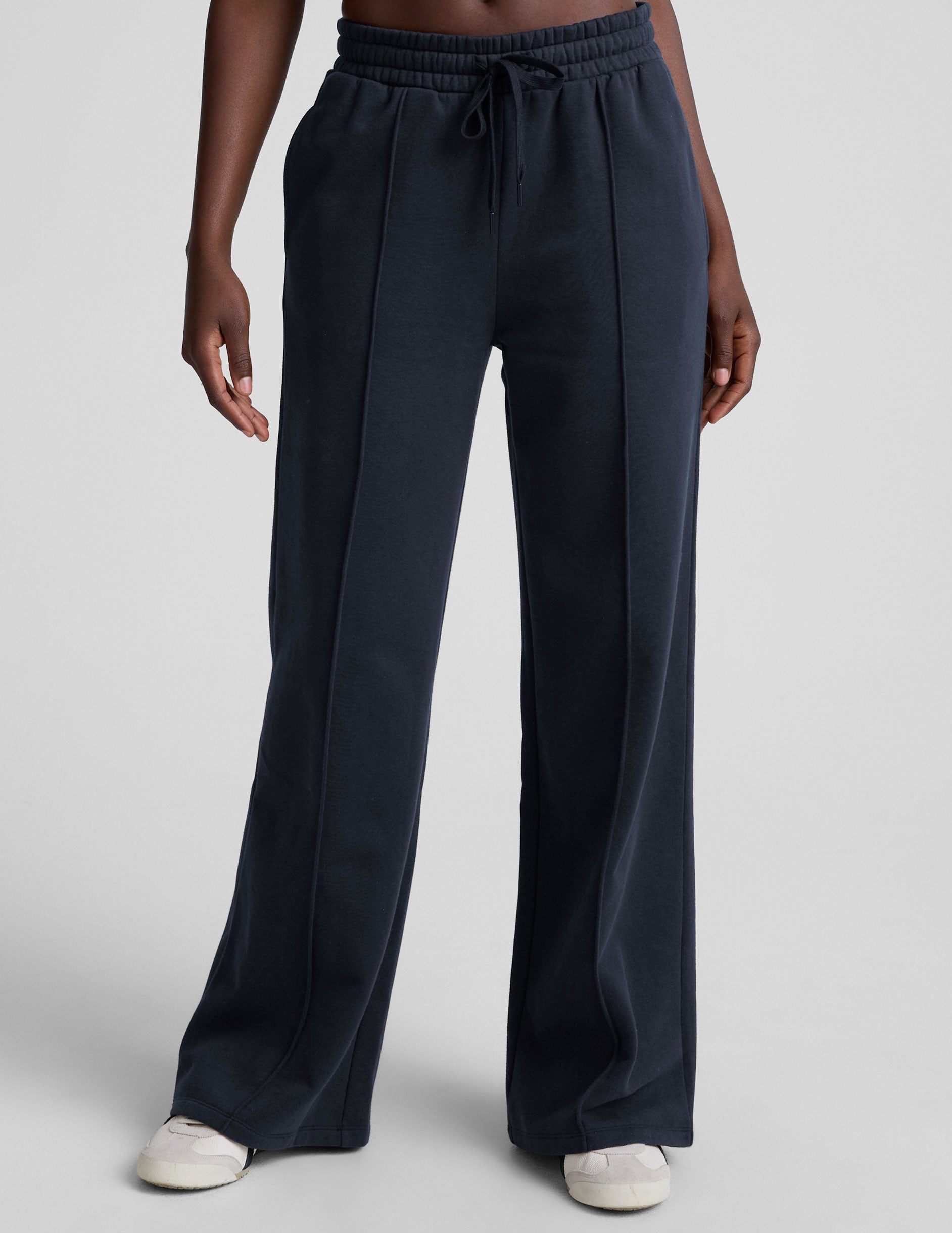 model is wearing blue fleece wide leg pants against a plain background.