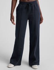 model is wearing blue fleece wide leg pants against a plain background.