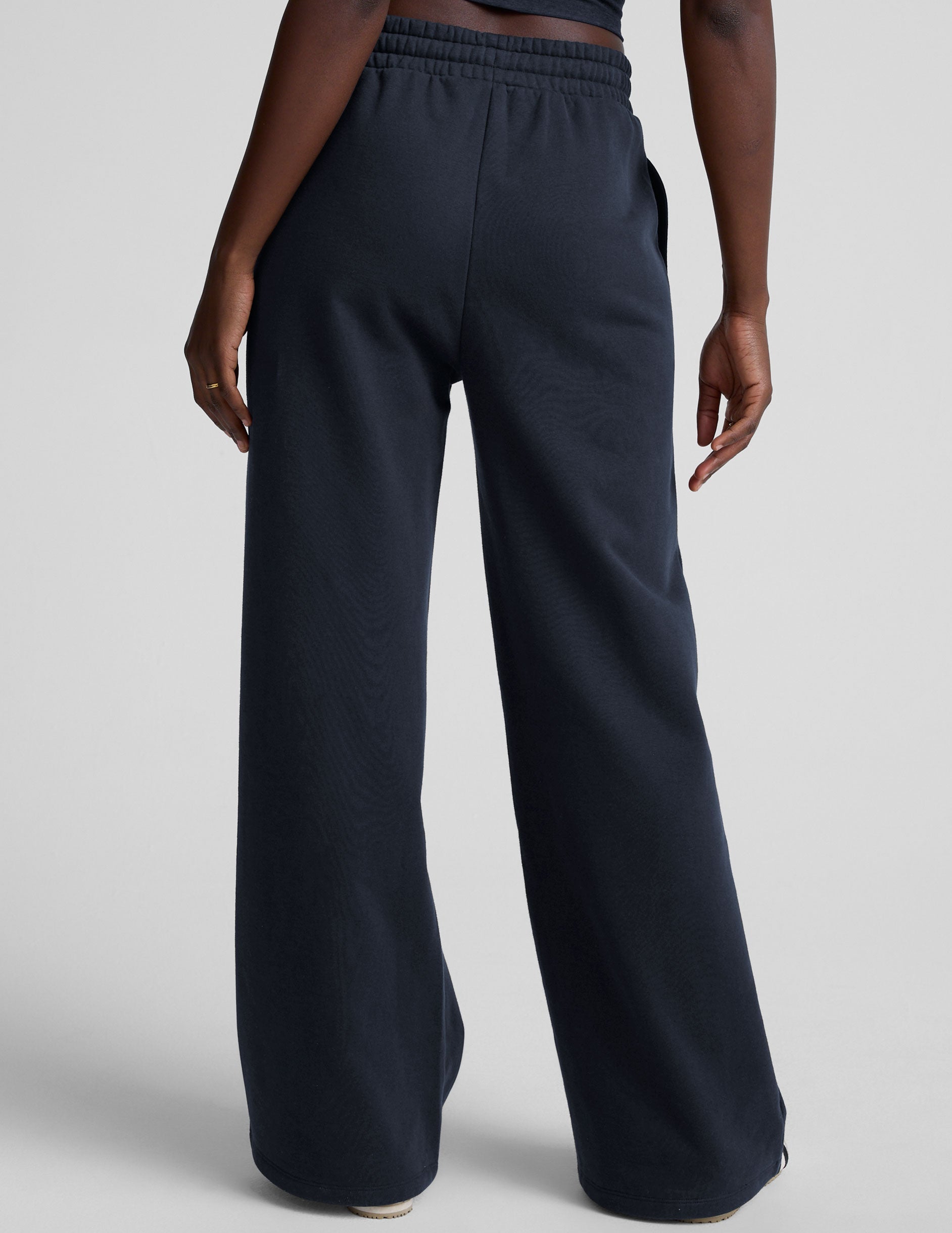 model is wearing blue fleece wide leg pants against a plain background.