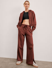 brown mid-rise wide leg sweatpants with side slits and a drawcord at waistband.