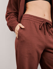 brown mid-rise wide leg sweatpants with side slits and a drawcord at waistband.