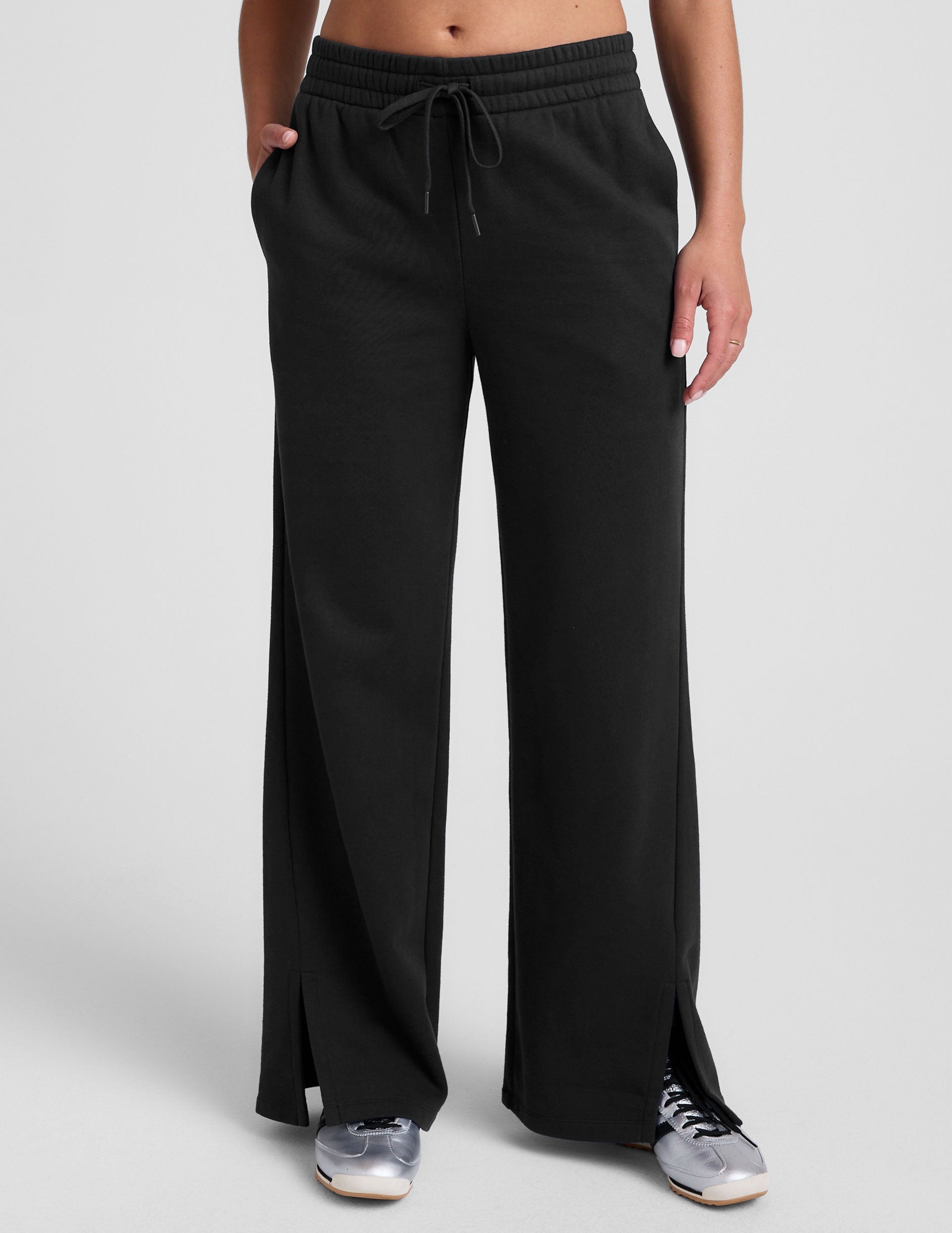 black mid-rise wide leg sweatpants with side slits and a drawcord at waistband.