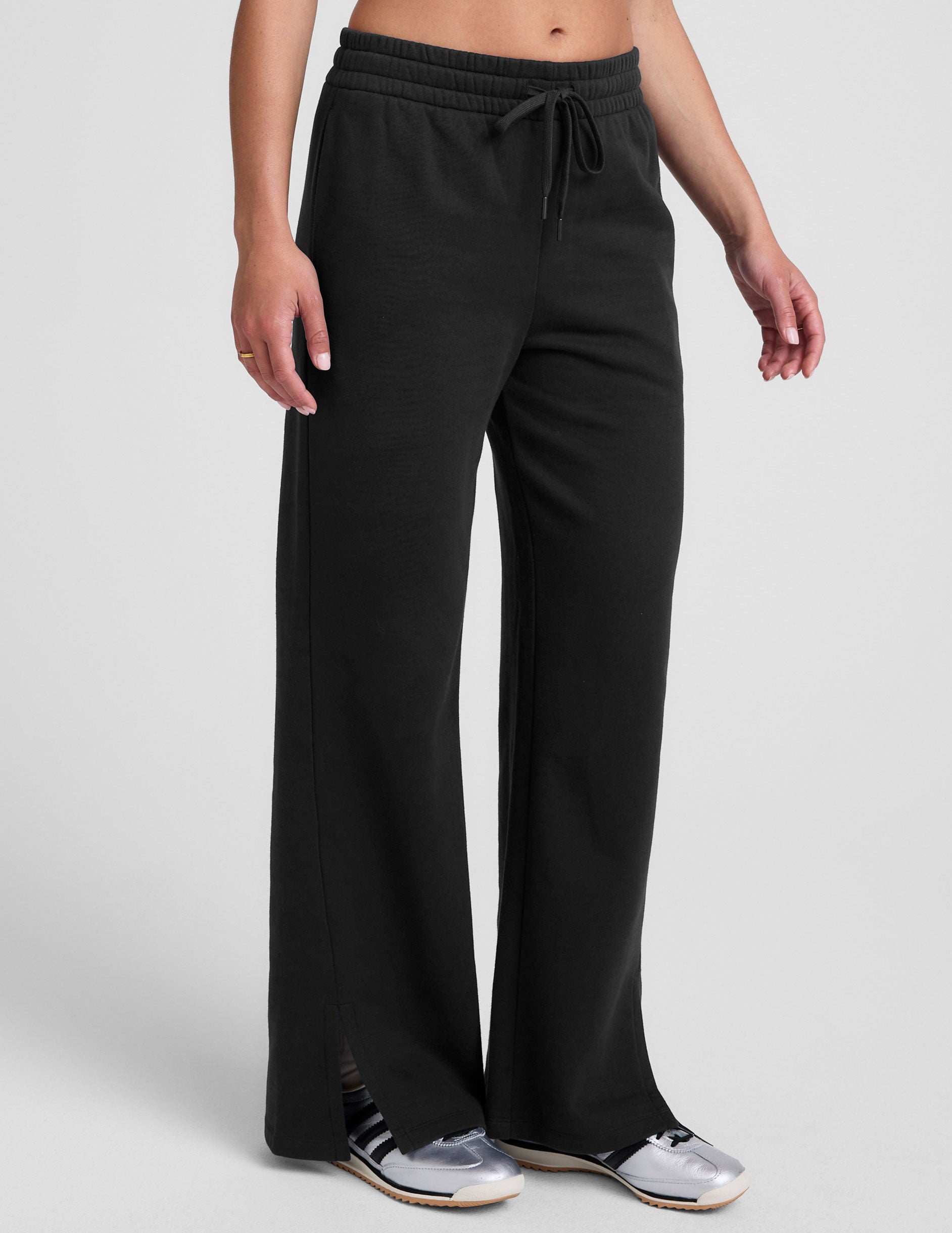 black mid-rise wide leg sweatpants with side slits and a drawcord at waistband.