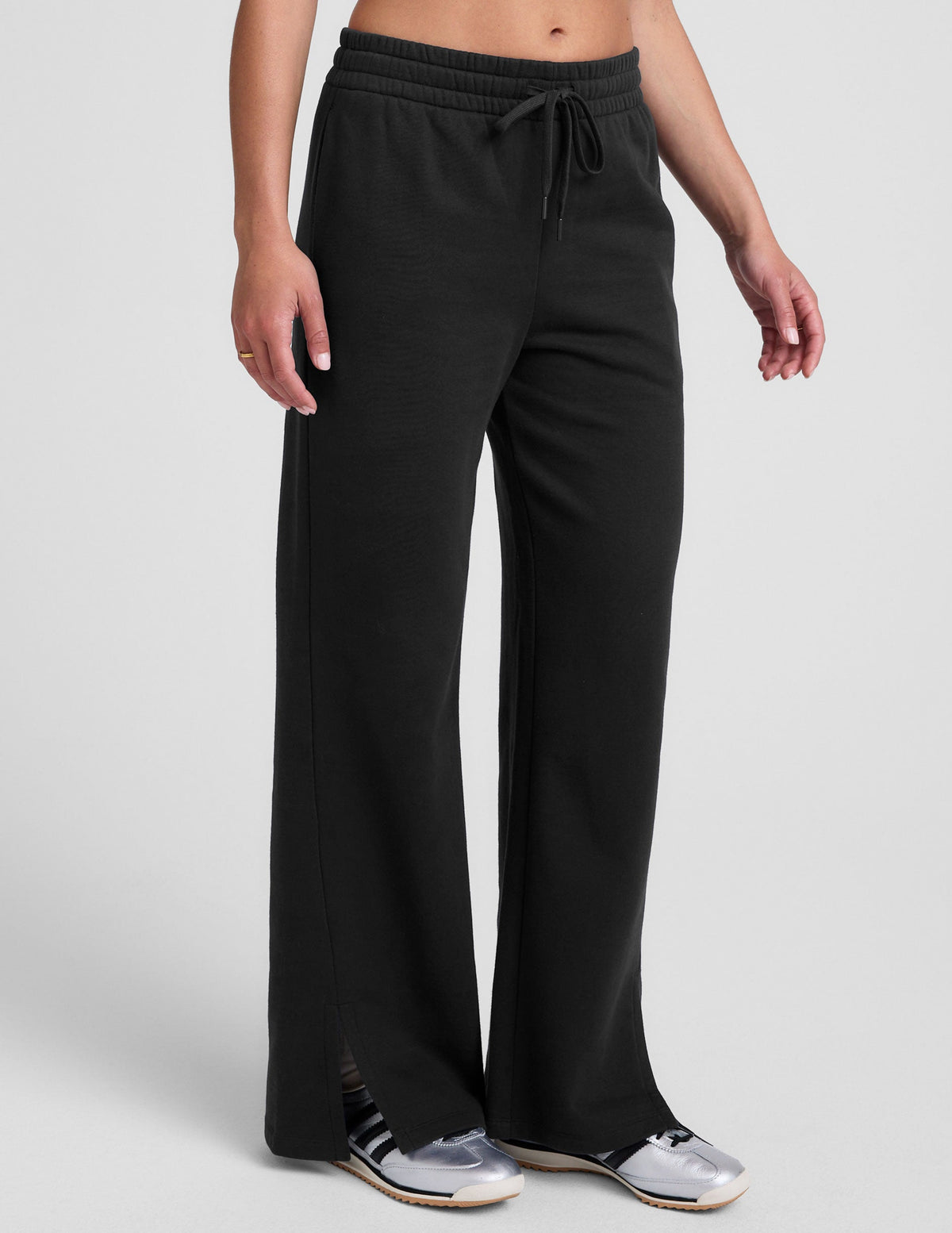 black mid-rise wide leg sweatpants with side slits and a drawcord at waistband.
