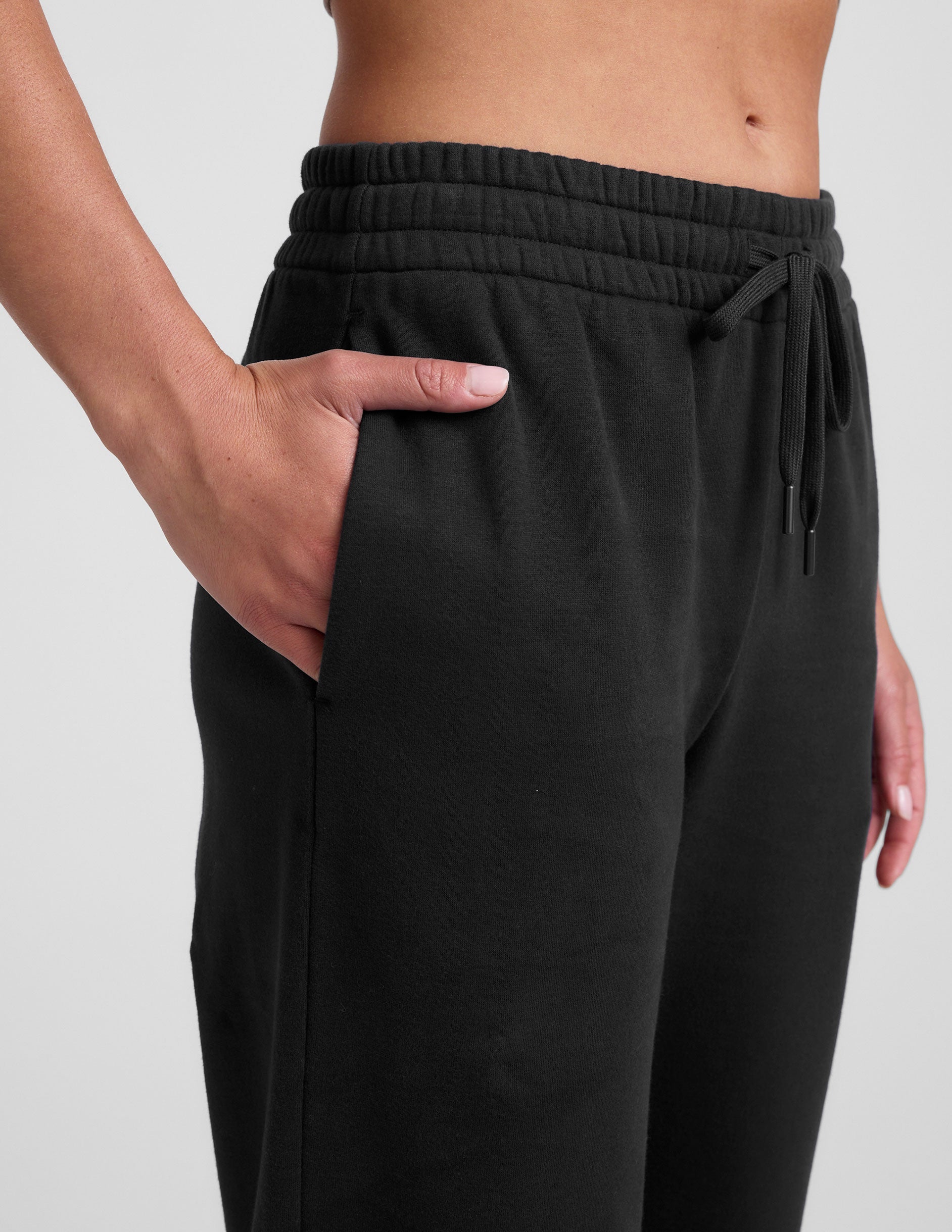 black mid-rise wide leg sweatpants with side slits and a drawcord at waistband.