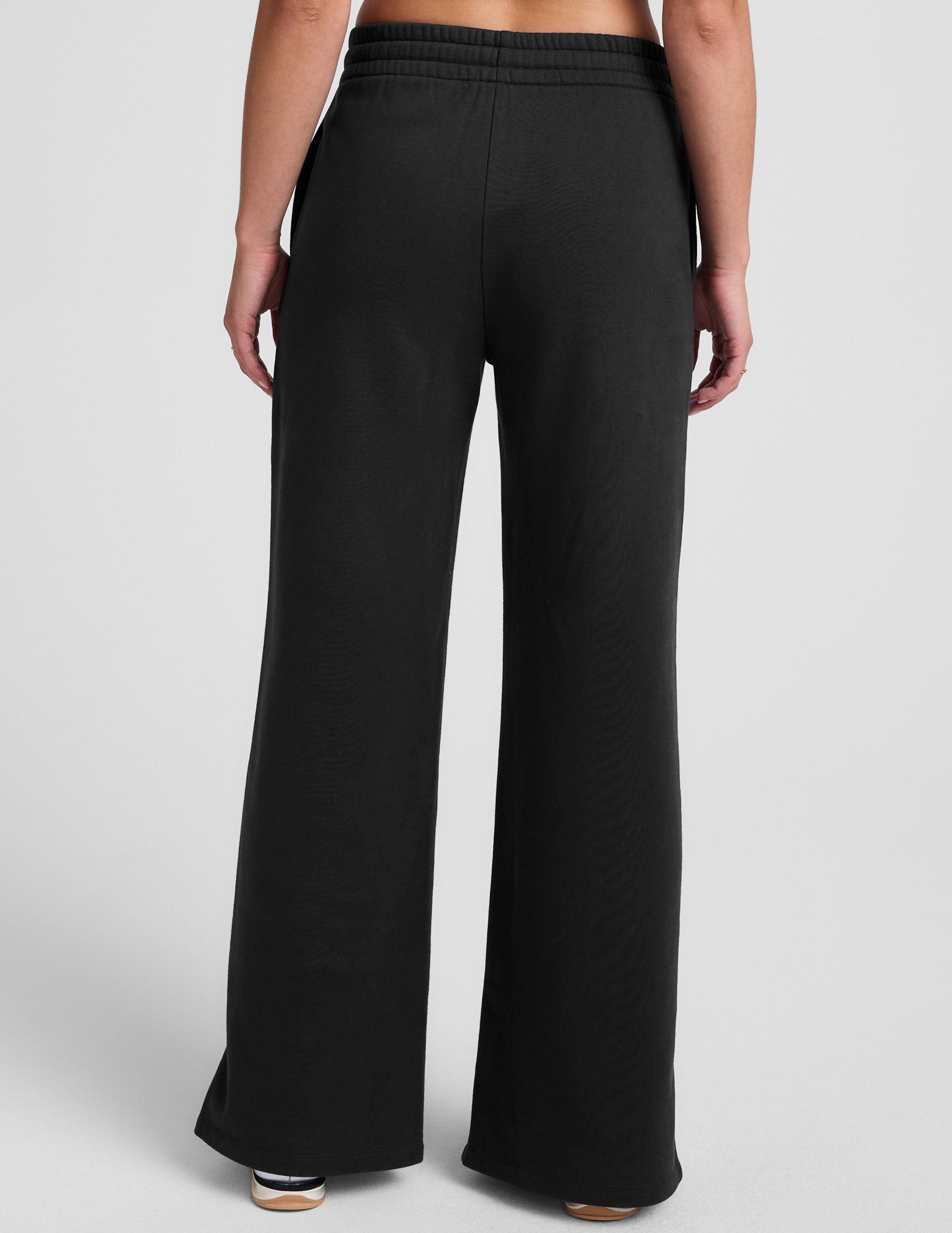 black mid-rise wide leg sweatpants with side slits and a drawcord at waistband.