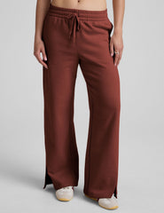 brown mid-rise wide leg sweatpants with side slits and a drawcord at waistband.